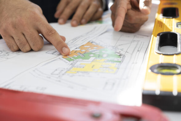 Photo de trois personnes qui montrent le plan coloré d'un bâtment. - Agrandir l'image, fenêtre modale