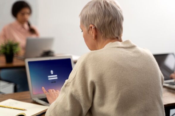 Photo d'une personne face à un ordinateur, parmi un groupe. - Agrandir l'image, fenêtre modale