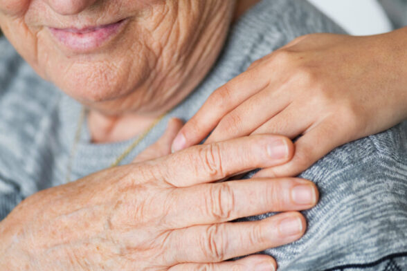 Photo d'une personne âgée qui touche une main posée sur son épaule. - Agrandir l'image, fenêtre modale