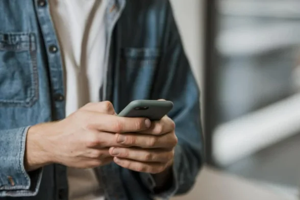 Photo d'une personne qui tient son smartphone. - Agrandir l'image, fenêtre modale