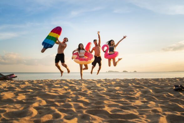 Photo de jeunes en maillots de bain sautant sur la plage devant un couché de soleil. - Agrandir l'image, fenêtre modale